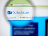 Foto che mostra il logo di Outlook.com sotto una lente di ingrandimento