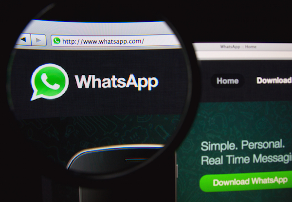 Foto che mostra il logo di WhatsApp su web ingrandito con una lente di ingrandimento