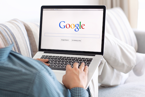 Foto che mostra un uomo che utilizza un computer con Google come pagina iniziale