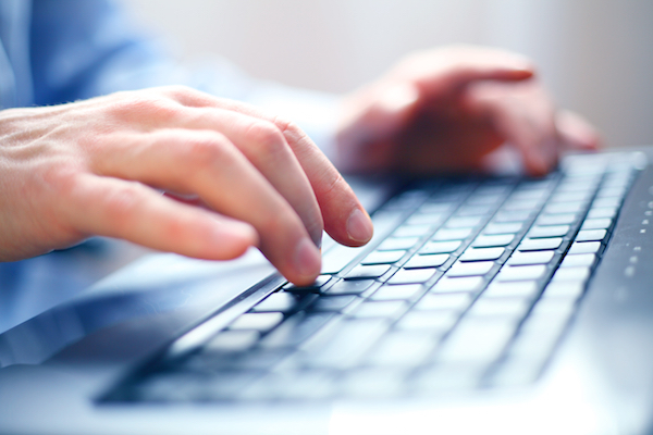 Immagine che mostra un uomo che digita sulla tastiera di un computer