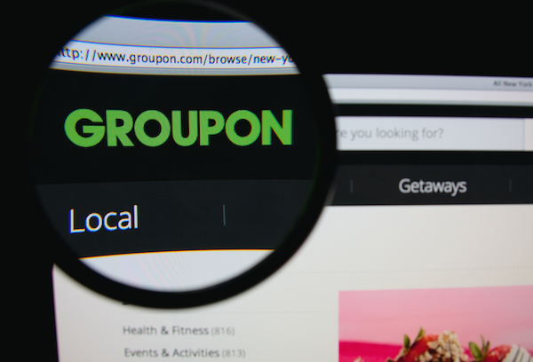 Foto che mostra il logo di Groupon sotto una lente