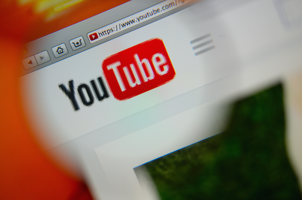 Foto che mostra il logo di YouTube sotto una lente