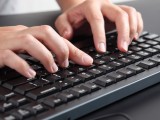 Foto che mostra un uomo che utilizza la tastiera di un computer