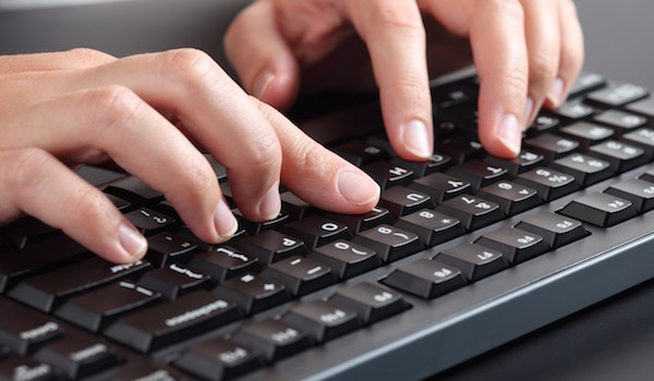Foto che mostra un uomo che utilizza la tastiera di un computer